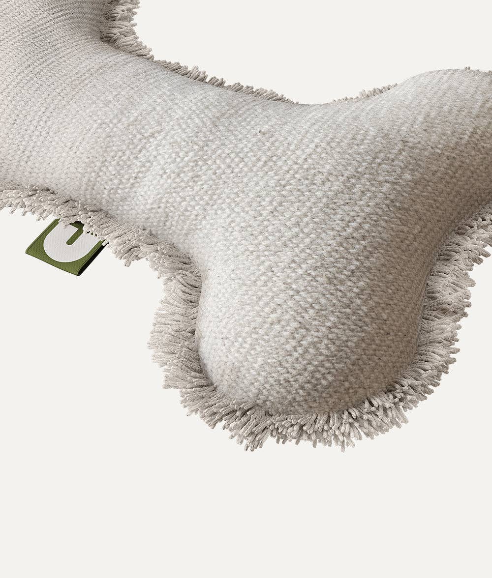A detailed view of the CAFIDE White Bone Dog Toy, Fleky, highlighting its soft organic cotton fabric, reinforced seams, and premium craftsmanship for durability.